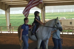 young-girl-on-horse-carrying-flag-to-kick-off-horse-show