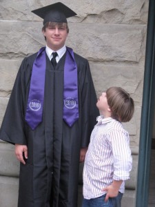 Little brother looks up at big brother on graduation night